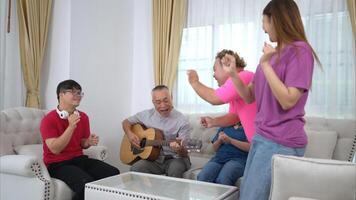 A grandfather with grandchild enjoys singing and dancing together at home during the holidays photo