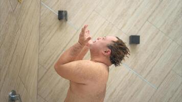 Young man gets wet before swimming in pool photo