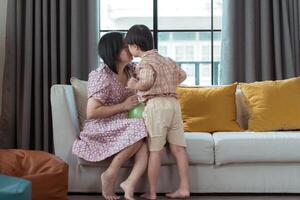 A special child and his mom having fun and relaxing on a holiday together in the living room of the house photo