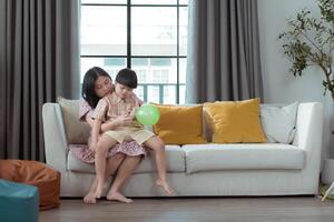 A special child and his mom having fun and relaxing on a holiday together in the living room of the house photo