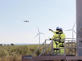 The engineering team is surveying the area to install a large wind turbine for converting wind energy into electricity photo