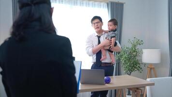 A business father assigns work to his secretary, while also taking care of his child while working photo