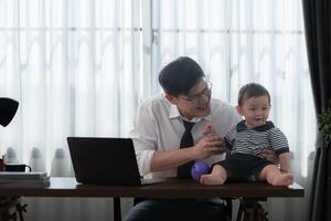 A business father and his duty to take care of his children while working photo