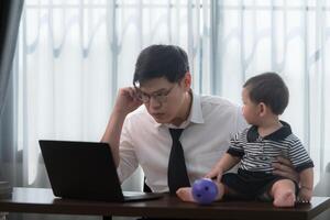 A business father and his duty to take care of his children while working photo