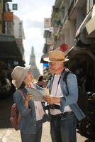 Elderly couples and their activities on the road at the end of the alley where there is a pagoda of Wat Arun, Thailand photo