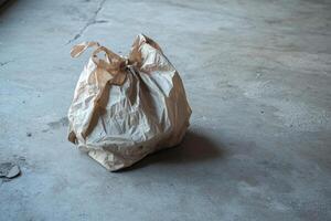 A Crumpled Paper Bag on a Concrete Floor photo