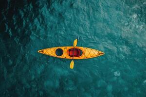 Overhead View of Yellow Kayak Paddling in Teal Water photo