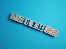 Sell Stock Decision, Right and Wrong Marks on Wooden Block photo