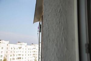 A modern vacuum robot window washer washes glass in an apartment on a balcony. View outside from the street. Safety from falls from a height. photo