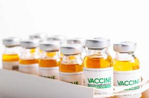Vials of coronavirus medicine are in packaging on a white background. Vaccine test concept in a laboratory, macro photo