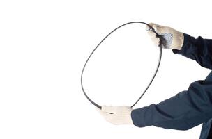 A car mechanic holds a used alternator rivulent belt on a white background, isolate. Background photo