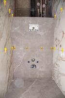 Laying modern large format tiles with the tile leveling system in the toilet. Laying tiles on the wall of the installation for the toilet. Copy space for text photo