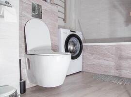 Modern renovation in the bathroom combined with a toilet. Hanging toilet and washing machine. Copy space for text photo