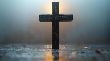 Symbolic wooden cross illuminated by soft light in a serene, misty environment at dawn photo
