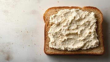 Creamy spread generously layered on whole grain bread for a delightful snack experience photo