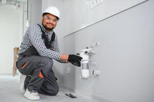 plumber installing water equipment - meter, filter and pressure reducer photo