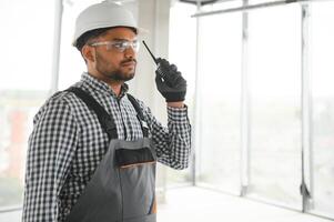 male builder in hardhat with walkie talkie or radio photo