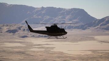 A helicopter flying over a snow covered mountain range video