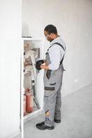 The worker installs or inspects Fire extinguisher and fire hose reel in building corridor photo