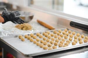Raw homemade cookies in the shape of heart on a baking sheet for baking. photo