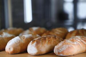 Freshly baked bread on bakery shelves. Bread diversity in bright light. Breads with a golden crust on wooden shelves photo