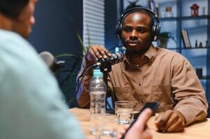 Man recording podcast using high tech microphones to interview guest, ensuring flawless and sound quality for audience photo