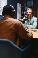 Man recording podcast using high tech microphones to interview guest, ensuring flawless and sound quality for audience photo