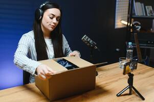 Cheerful fashion influencer excitedly displays new products during a live unboxing session photo