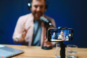 Man smiling while recording podcast in studio photo
