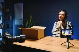 A female vlogger records a of unpacking new stylish clothes on camera photo
