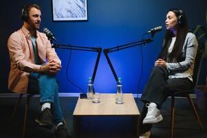 Two Young Stylish Radio Show Hosts Record Fresh Podcast Episode in Studio. Attractive Energetic Co-hosts Discuss Important Topics Live on Air in an Evening Show photo