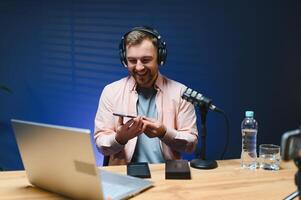 Joyful young man recording unboxing in studio photo