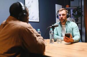 Podcasters enjoying happy conversations with online listeners in studio, covering wide range of subjects photo