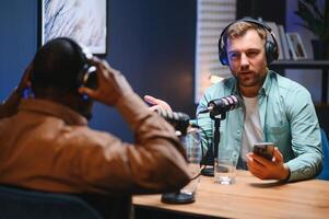 Man recording podcast using high tech microphones to interview guest, ensuring flawless and sound quality for audience photo
