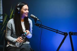 Female podcaster in headphones interviewing man guest using microphone, smiling, recording and broadcasting audio podcast in studio. Content creator, blogging photo