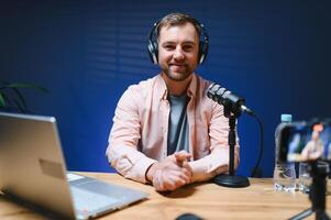 vlogger using smartphone to film podcast in studio. blogger with mobile phone, microphone and headphones filming for social media broadcasting career photo