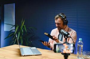 Joyful young man recording unboxing in studio photo