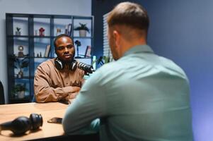 Man recording podcast using high tech microphones to interview guest, ensuring flawless and sound quality for audience photo