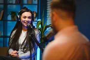 Side view of successful woman hosting podcast interviewing man while recording with professional microphones, copy space photo