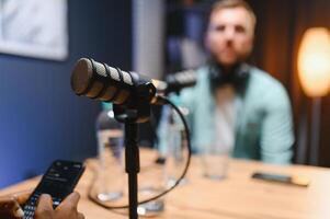 Focus on professional microphone and podcast host in background photo