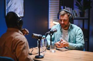 Man recording podcast using high tech microphones to interview guest, ensuring flawless and sound quality for audience photo