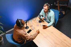 Man recording podcast using high tech microphones to interview guest, ensuring flawless and sound quality for audience photo