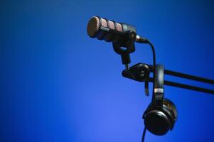 Close up shot of podcast microphone used to record conversations for internet livestreaming show. Streaming sound capturing and recording technology in empty home studio with neon lights photo