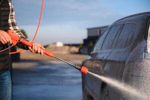 Car is washed at a professional car wash. Man washes a car with foam. Detailing photo