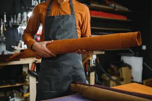 work in leather shop on dark background photo