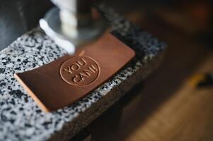 leather craftsman is carefully to make a leather product for a customer. Leather craftsman concept photo