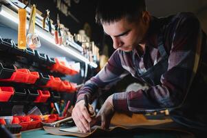 work in leather shop on dark background photo