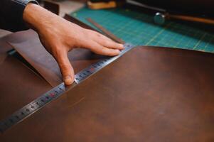 leather craftsman is carefully to make a leather product for a customer. Leather craftsman concept photo