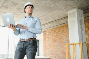 Supervisor using laptop at construction site photo