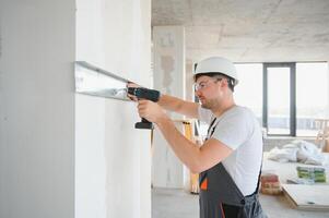 Construction worker installing metal profile for interior partition wall, while building a new house or renovation process photo
